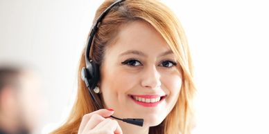 A woman smiling with a telephone headset on