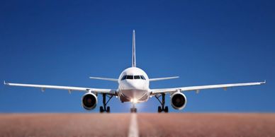 A small white aircraft on the runway preparing to take off