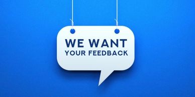A hanging label on a blue background with the words "we want your feedback"