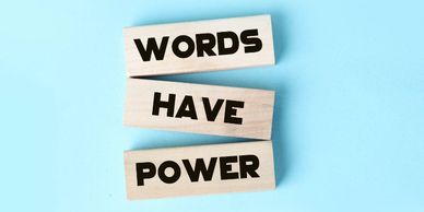 Words have power printed on small pieces of wood on a light blue background