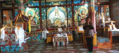 Interior of a vibrant Buddhist temple with statues and visitors.