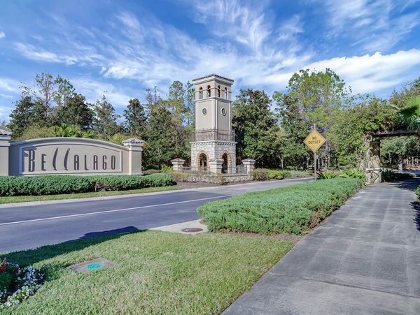 Entrance to Bellalago community with tower and clear blue sky.