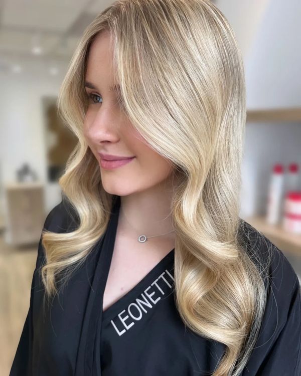 Woman with long, wavy blonde hair and a subtle smile.