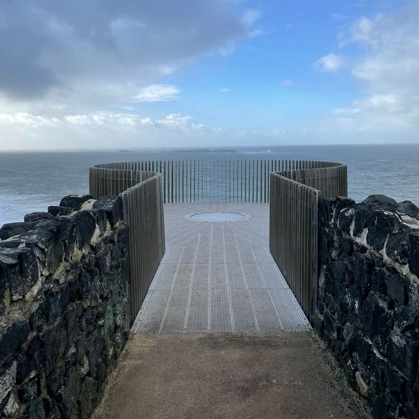 Circular viewpoint on cliffs looking out to sea. Changing sky as storm is passing, sky brightening