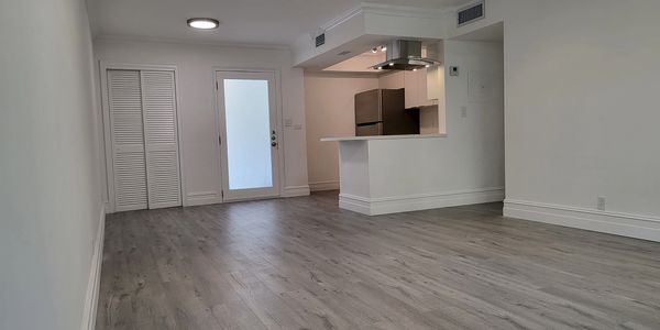 Bright and airy living room faces open kitchen