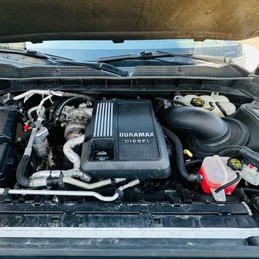 Open hood showing Duramax diesel engine inside a vehicle.