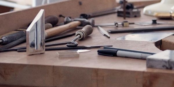 tools and silver items on a bench.