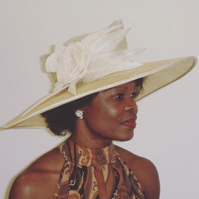 Large sinamay hat decorated with flowers and feathers.