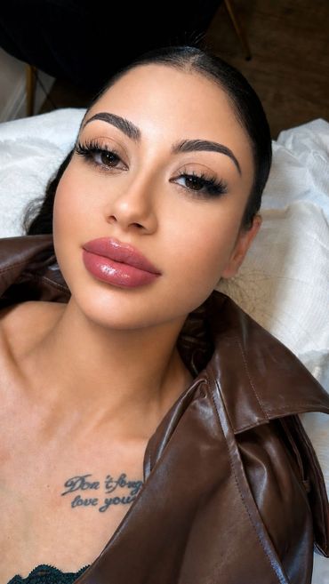 Close-up of a woman with flawless makeup and glossy lips.