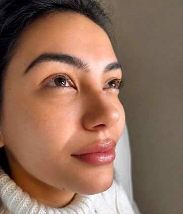 Close-up of a woman gazing upward, showing clear skin and natural beauty.