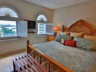 Cozy bedroom with wooden bed and windows.