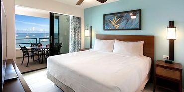Cozy bedroom with ocean view balcony.