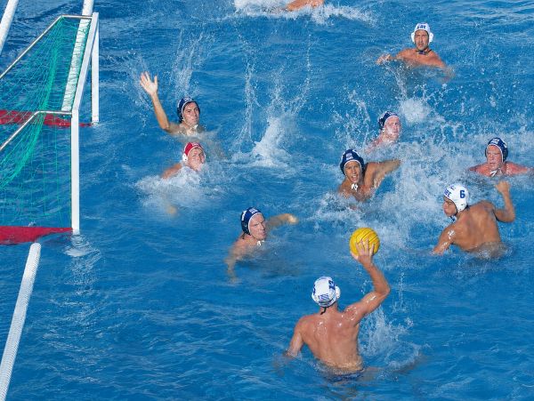 Players in a water polo match competing near the goal.