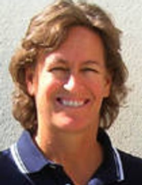 Smiling woman with short curly hair in a navy polo shirt.