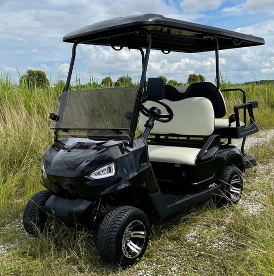Black VIVID EV golf cart in a field