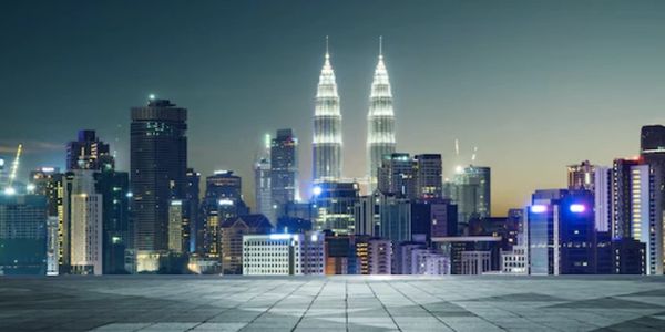 Night view of a modern city skyline with illuminated skyscrapers.