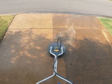 Pressure washing a driveway, showing a clear clean path.