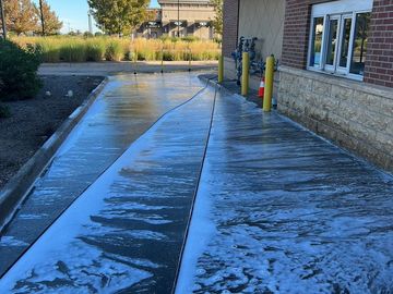 A freshly washed drive-thru lane with soap suds on the ground.