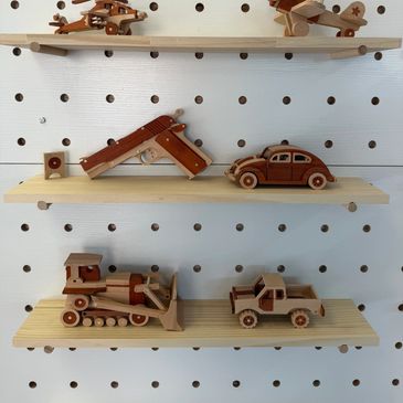 Wooden toy collection on pegboard shelves including vehicles and animals.