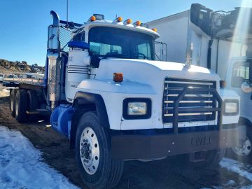 White semi-truck parked outdoors on a sunny day.