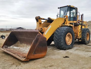 Yellow front loader with large bucket at construction site.