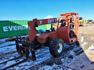 Orange Skytrak forklift on snowy ground.