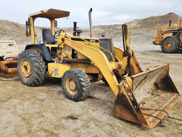 Old yellow construction loader on a dirt site.
