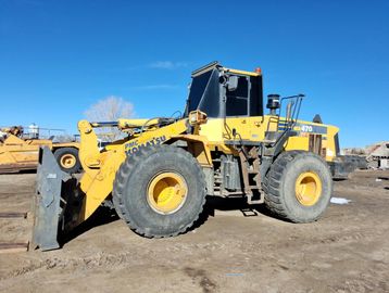 Yellow heavy-duty loader on dirt ground.