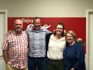 Smiling group of friends standing and making eye contact with the camera