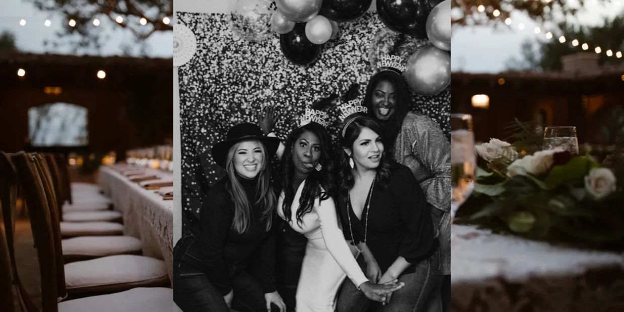 Group of four women celebrating New Year's with hats and balloons.