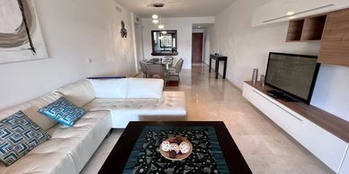 Modern living room with white sectional sofa and TV.