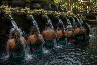People participating in a water purification ritual at a temple.