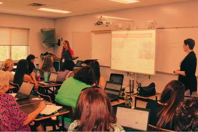 Presenters talking to teachers in a classroom