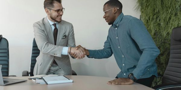 Consultant and client warmly shaking hands