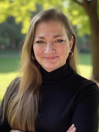 Smiling woman with long blonde hair wearing a black turtleneck outdoors.