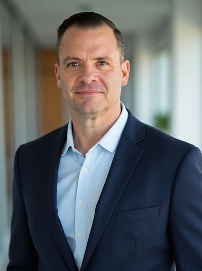Professional man in a navy suit with a confident expression.