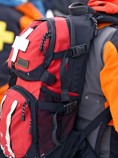 Rescue team members in orange and gray uniforms with medical backpacks.
