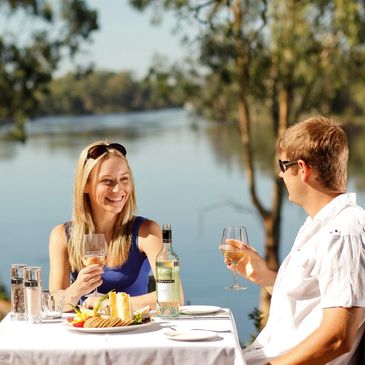 trentham view of river woman and man at a table drinking wine and eating 