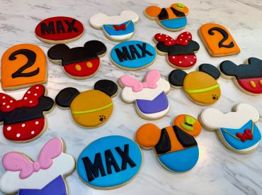 Cookies decorated with colorful Mickey and Minnie Mouse themes.
