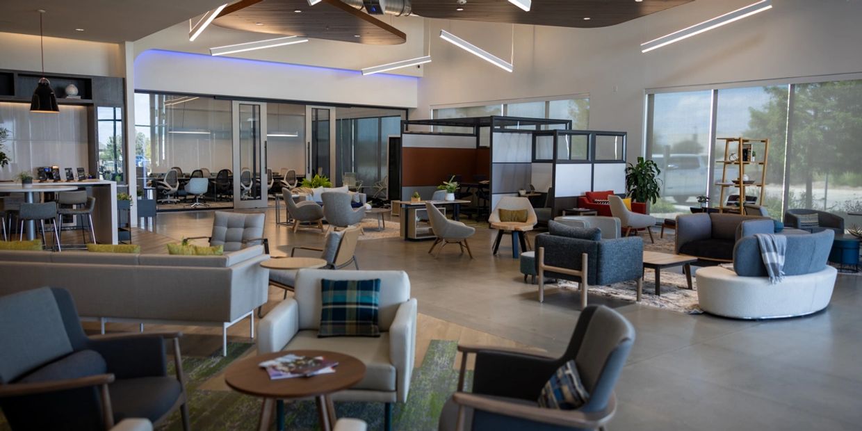Modern open office space with seating areas and meeting rooms.