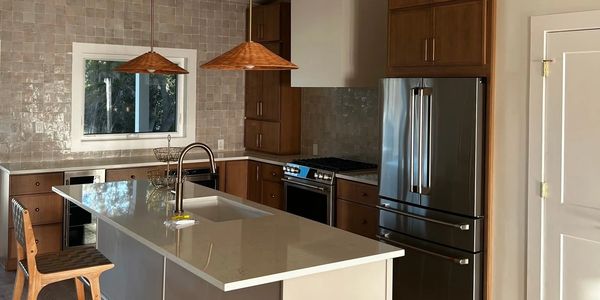 Modern kitchen with island and stainless steel appliances.