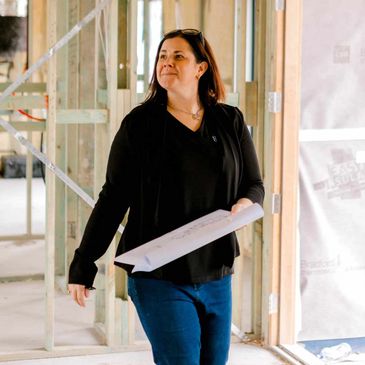 Woman holding architectural plans at a construction site.