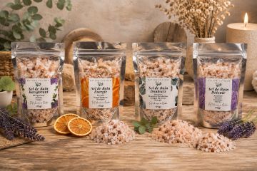 Quatre sachets de sels de bain aromatiques sur une table en bois.