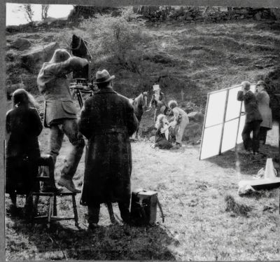 Black and white photo of a film crew shooting a scene outdoors.
