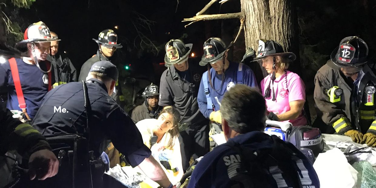 A paramedic hold the hand of a victim entrapped in a car wreck and the firefighters and rescue team create a plan to free him. 