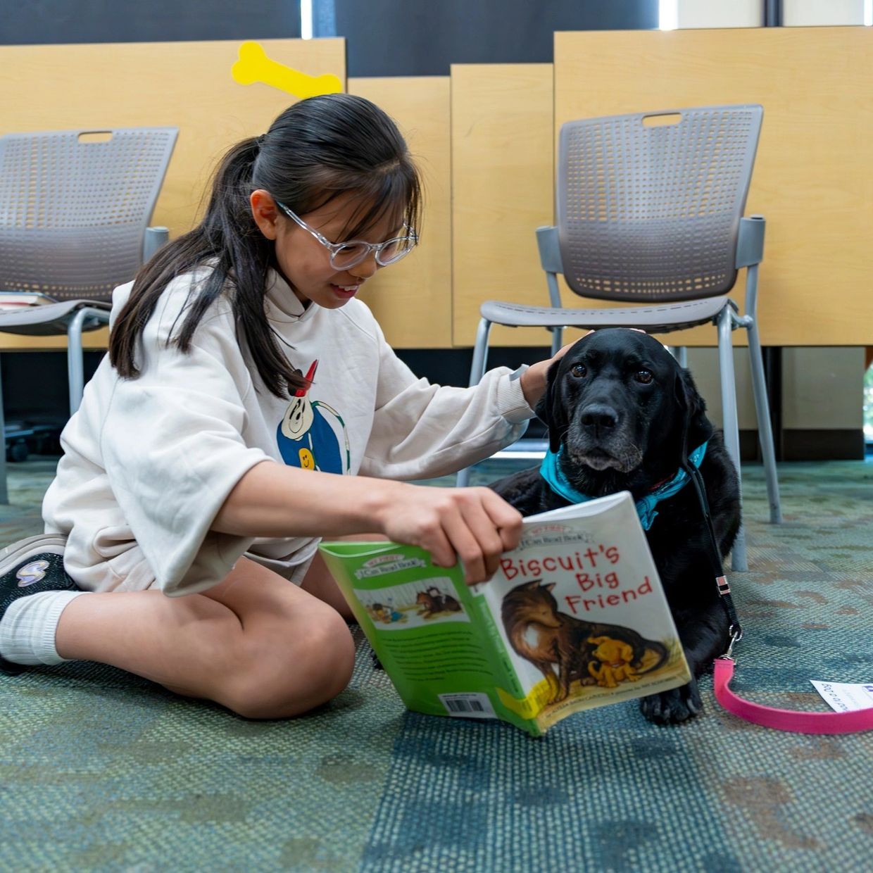 Girl reading a book with a dog