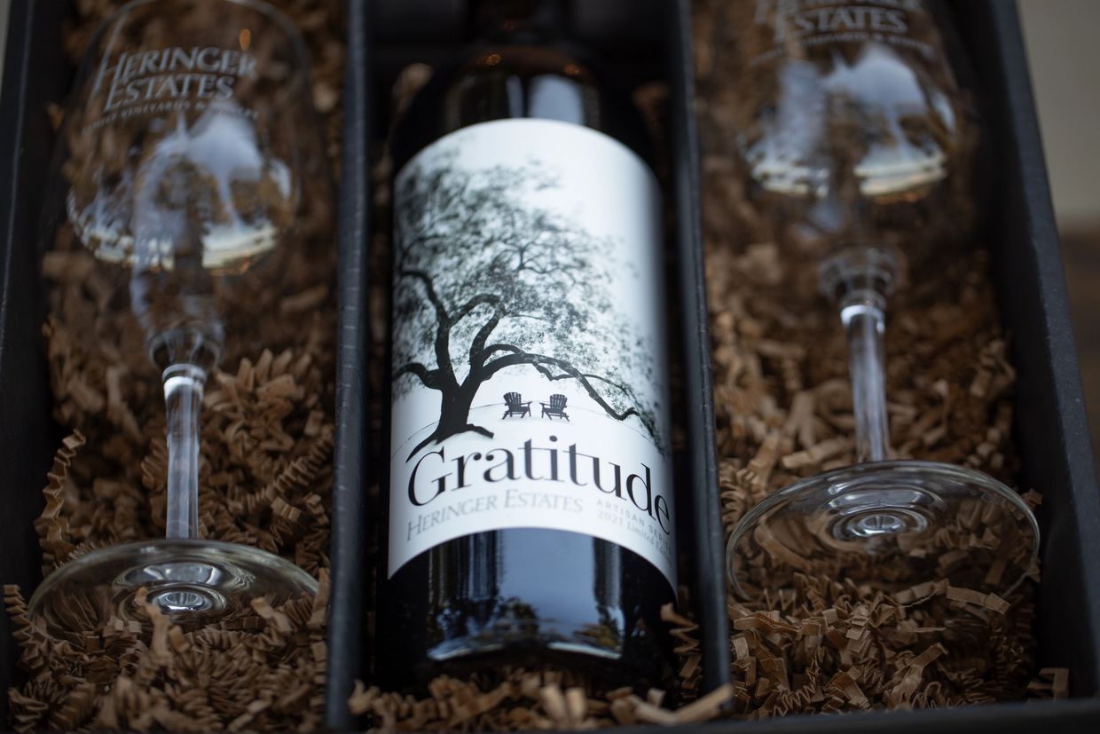 A wine gift set with a 'Gratitude' wine bottle and two Heringer Estates glasses.