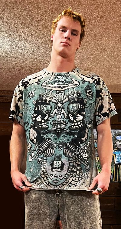 Young man wearing a graphic t-shirt with artistic skull designs.