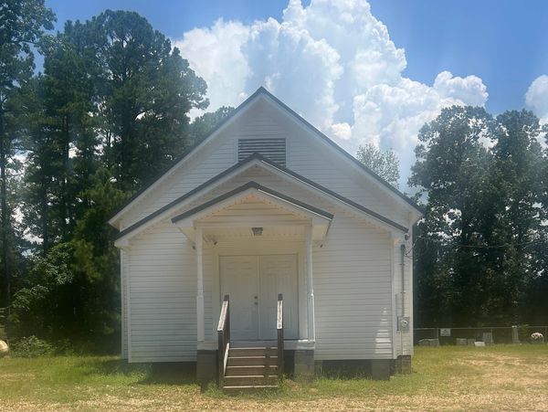 Small white building under blue sky.