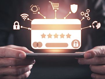Hands holding a smartphone with a glowing credit card and security icons above.